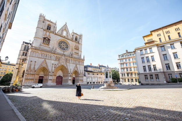 Poranny widok na katedrę św. Jana z kobietą spacerującą po placu na starym mieście w Lyonie