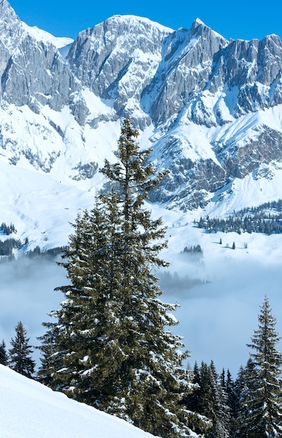 Poranny zimowy krajobraz górski z chmurami w dolinie (region Hochkoenig, Austria)