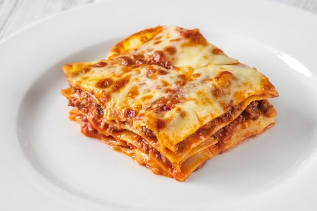 Porcja lasagne na bielu talerzu