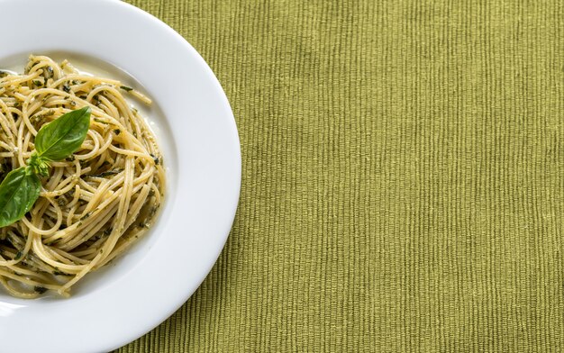 Porcja makaronu z sosem pesto i liściem bazylii