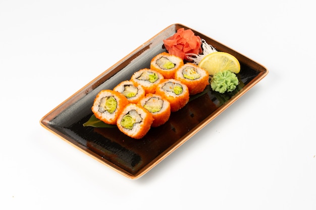Porcja maki sushi z asortymentem japońskich przystawek w prostokątnym talerzu ceramicznym na białym tle