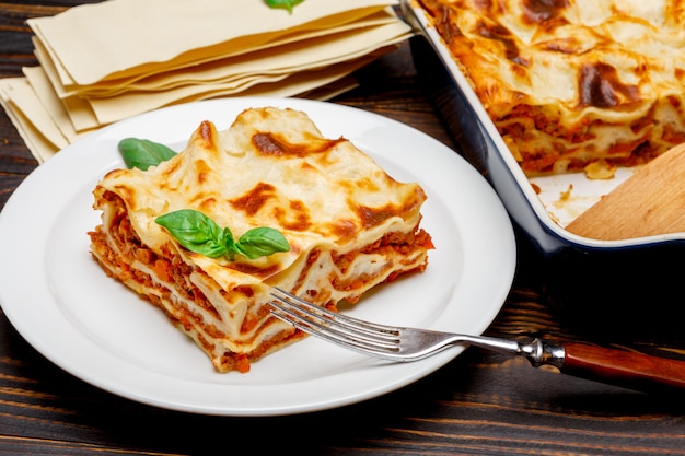 Porcja smakowita lasagna na drewnianym backgound