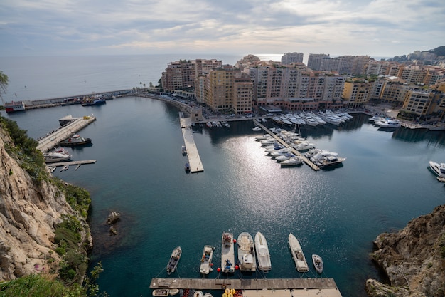 Zdjęcie port de fontvieille w azur wybrzeżu na wschodzie słońca z niebieskie niebo chmurą. cenne apartamenty i port z luksusowymi jachtami w zatoce, monte carlo, monako, europa