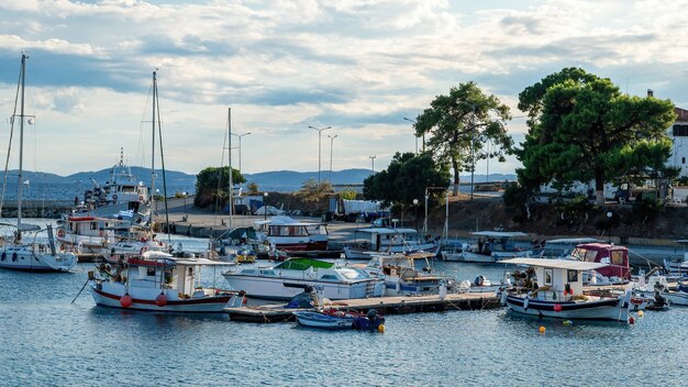 Port Morza Egejskiego z wieloma zacumowanymi jachtami i łodziami, drewniane molo, bezchmurna pogoda w Neos Marmaras w Grecji