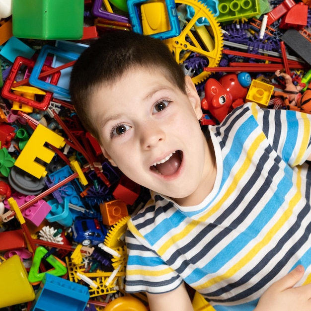 Portret 5-letniego chłopca na tle rozrzuconych zabawek