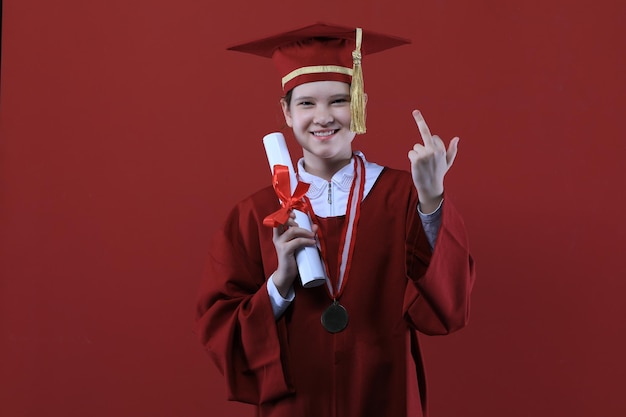 portret absolwentki w czapce dyplomowej na czerwonym tle