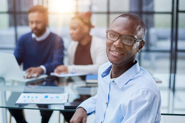 Portret African American biznesmen siedzi przy biurku w biurze