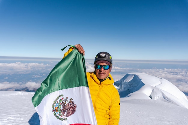 Portret alpinisty w wulkanie cayambe z flagą emexico