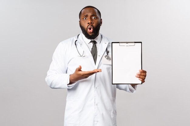 Portret amerykanina afrykańskiego pochodzenia lekarz lub lekarka w bielu mundurze.