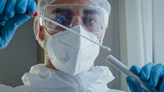 Portret arabskiego latynoskiego mężczyzny, lekarza, pracownika medycznego w kombinezonie ochronnym PPE, wykonał wymaz z przekrwienia