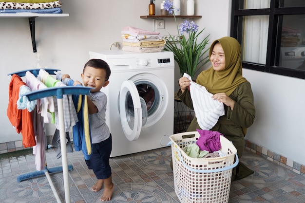 Portret asian szczęśliwa matka i syn razem robi pranie w domu
