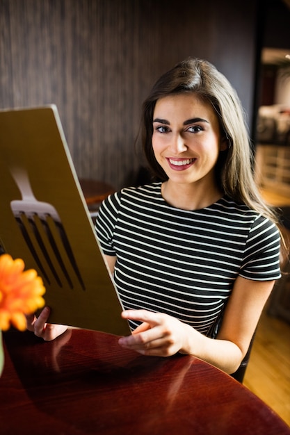 Portret Atrakcyjna Brunetka Wybiera W Menu Przy Restauracją