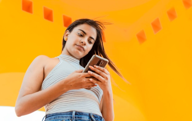 Portret atrakcyjna latynoska dziewczyna wysyłająca wiadomości na telefon komórkowy Niski kąt pięknej latynoskiej dziewczyny korzystającej ze smartfona