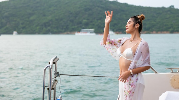 Portret Atrakcyjna Szczęśliwa piękna seksowna Azjatycka kobieta ubrana w strój kąpielowy, ciesząca się na pokładzie łodzi, żeglując luksusowym jachtem Wycieczka na wakacje letnie wakacje