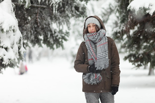 Portret atrakcyjnej kobiety w ciepłych ubraniach w zimową śnieżną pogodę na zewnątrz