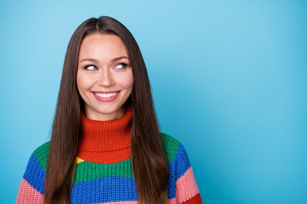 Portret atrakcyjnej ładnej słodkiej dziewczyny wygląda dobrze w stylu copyspace stylowy modny sweter izolowany na niebieskim tle koloru
