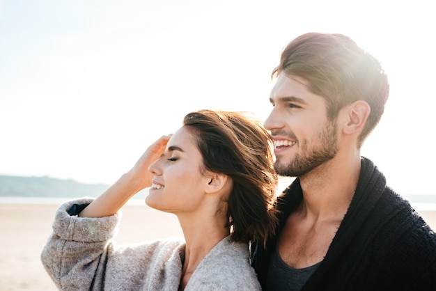 Portret atrakcyjnej młodej pary spędzającej razem dobry czas na plaży jesienią