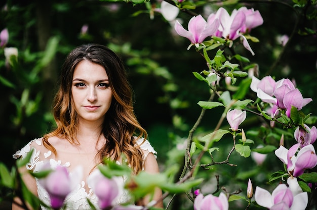 Portret Atrakcyjnej Narzeczonej Na Tle Różowych Kwiatów Magnolii I Zieleni.