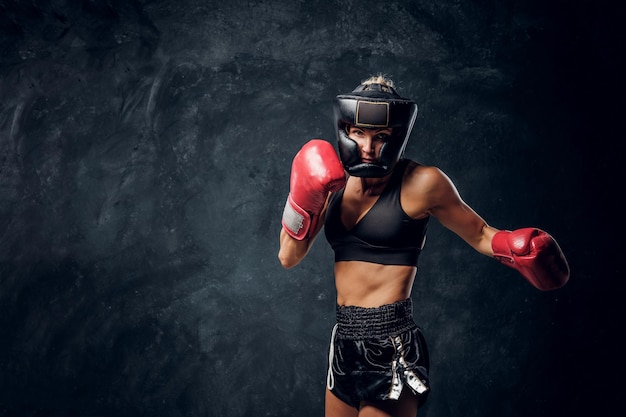 Portret atrakcyjny bokser w ochronnym kasku i rękawiczkach gotowych do walki.