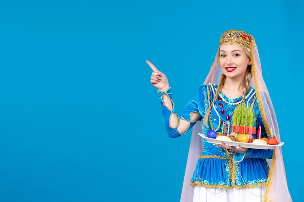 Portret azerskiej kobiety w tradycyjnym stroju z novruz xonca studio strzał niebieskie tło koncepcja etniczna wiosna