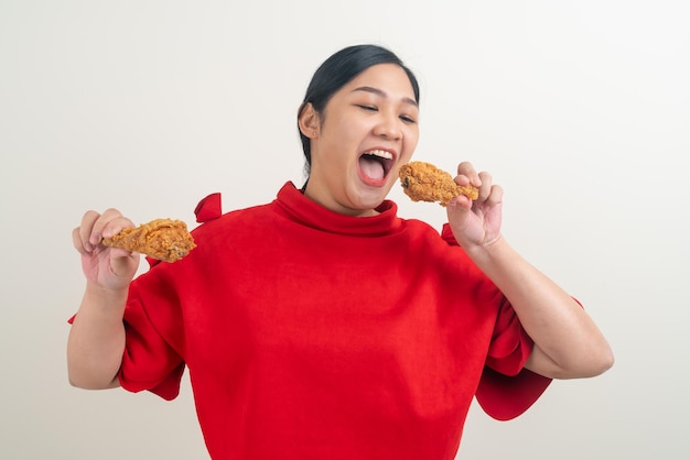 Portret Azjatycka kobieta ze smażonym kurczakiem na dłoni