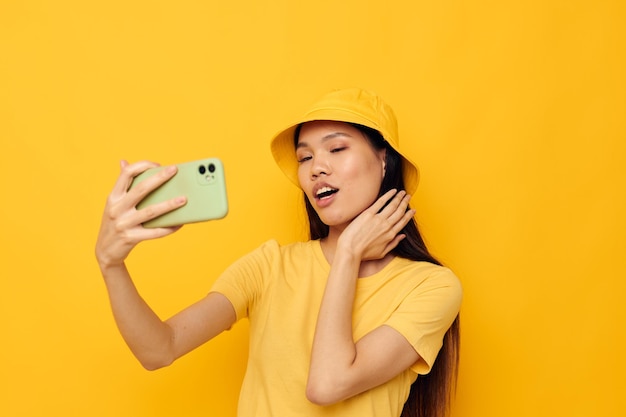 Portret Azjatycka piękna młoda kobieta w żółtym kapeluszu i Tshirt rozmawia przez telefon Styl życia niezmieniony