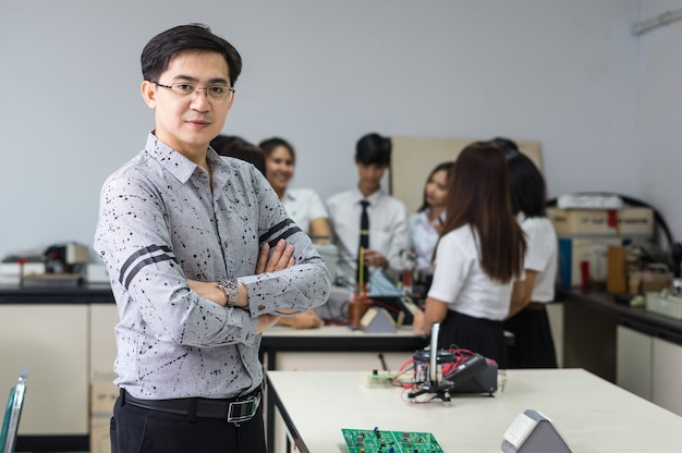 Portret Azjatycki nauczyciel przed studentami collegu w laboranckiej sala lekcyjnej