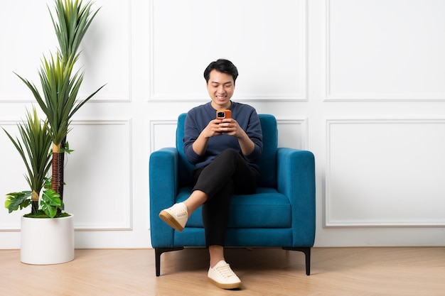 Portret azjatyckiego mężczyzny siedzącego na kanapie w domu