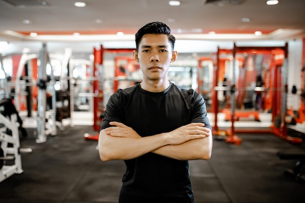 Portret azjatyckiego młodego człowieka w odzieży sportowej na siłowni fitness koncepcja ćwiczeń fitness i zdrowego stylu życia