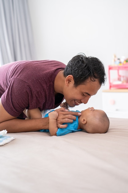 Portret azjatyckiego ojca zmieniającego pieluchę dla niemowląt w domu