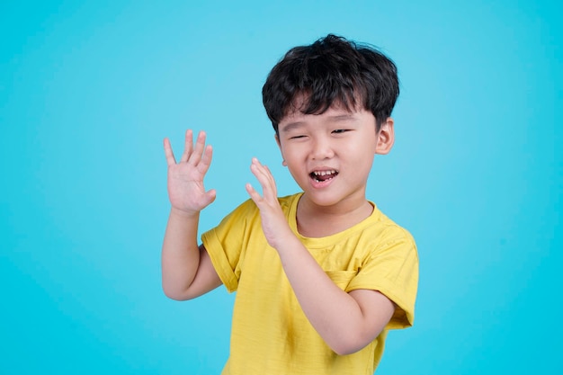 Portret azjatyckiego przystojnego małego chłopca na białym tle na niebieskim tle