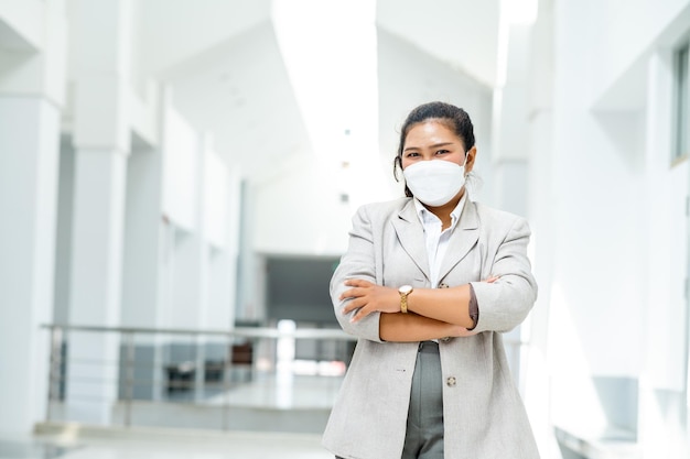 Portret azjatyckiej bizneswomy noszącej maskę chirurgiczną uśmiecha się do kamery