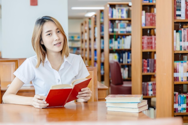 Portret azjatyckiej dziewczyny na uniwersytecie w bibliotece szczęśliwy uśmiech