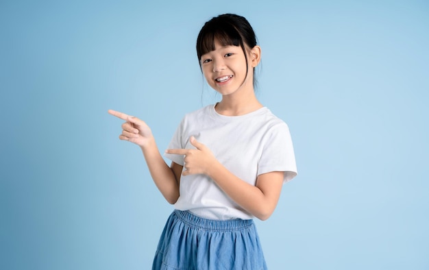 Zdjęcie portret azjatyckiej dziewczyny pozującej na niebieskim tle