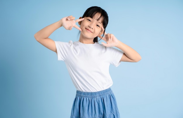 Portret azjatyckiej dziewczyny pozującej na niebieskim tle