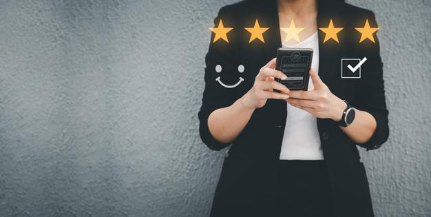 Portret azjatyckiej kobiety pracującej, ubranej w czarny garnitur, trzymającej telefon komórkowy podłączony do Internetu w celu wysłania informacji o pracy. Koncepcja wykorzystania technologii internetowej w życiu codziennym