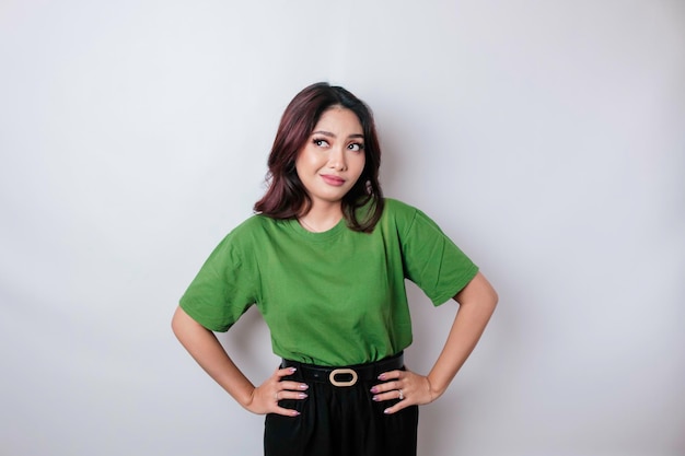 Portret azjatyckiej kobiety ubranej w zieloną koszulkę wygląda tak zdezorientowany na białym tle