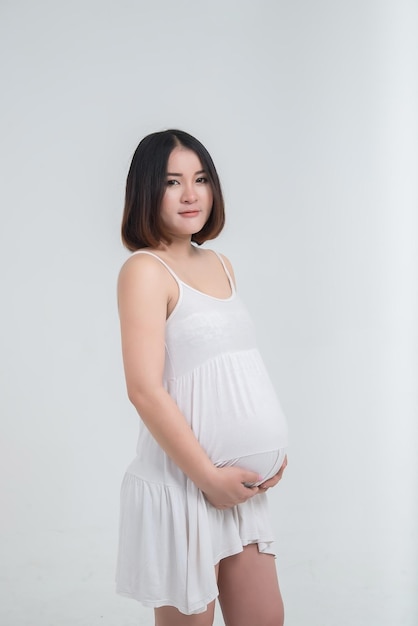 Portret azjatyckiej kobiety w ciąży na białym tleTajlandia ludzie używają brzucha dotykają dłoni