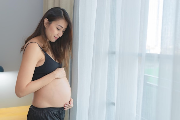 Portret azjatyckiej kobiety w ciąży w sypialniKoncepcja szczęśliwego dnia matki