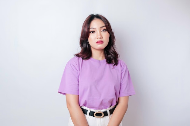 Portret azjatyckiej kobiety w liliowo-fioletowej koszulce odizolowanej na białym tle wygląda na przygnębionego