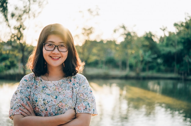 Portret azjatykcia kobieta ono uśmiecha się jaskrawy w parku