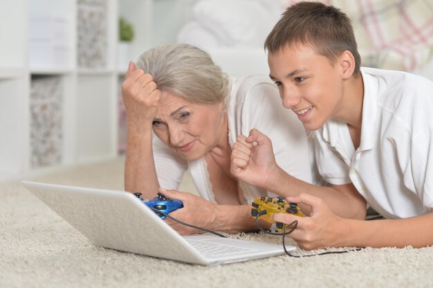 Portret babci i wnuka grających w grę komputerową