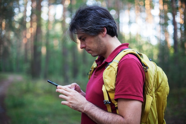 Portret backpacker patrząc na nawigator GPS, urządzenie globalnego systemu pozycjonowania