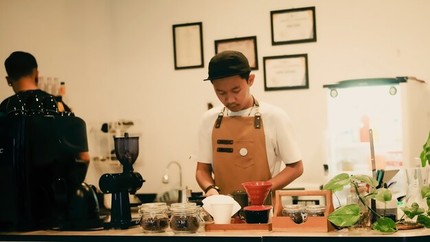 portret baristy robiącego kawę metodą aeropress