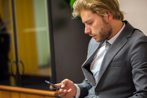 Portret biznesmen używa jego telefon komórkowego