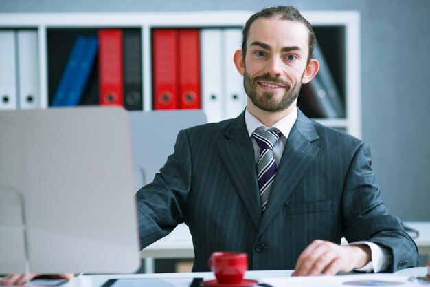 Portret biznesmen w biurze przy biurkiem