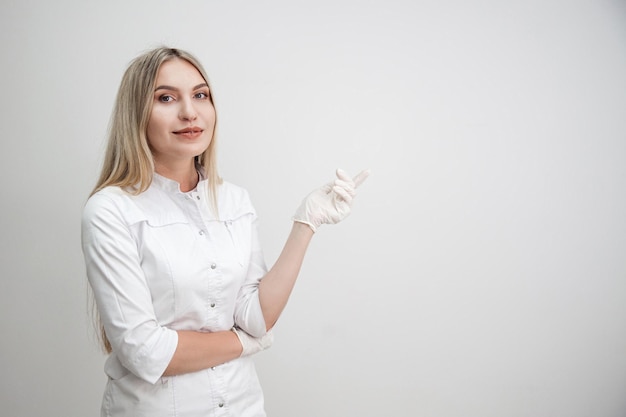 Portret blond kobieta lekarz w białym fartuchu i białych rękawiczkach na białym tle Kopiuj przestrzeń