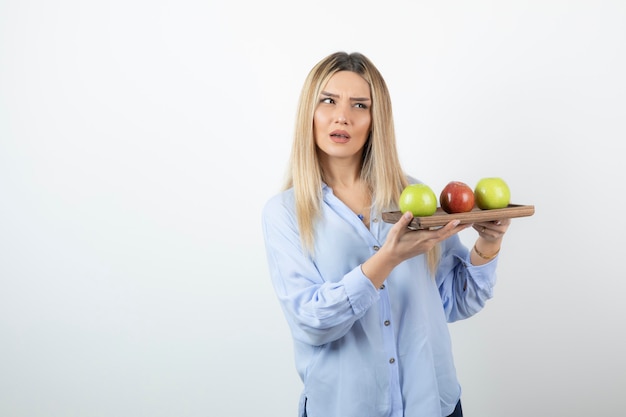 Portret Blondynka Trzyma Deskę Z Zielonymi I Czerwonymi Jabłkami