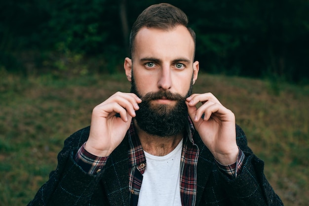 Portret brodaty hipster mężczyzny w lesie