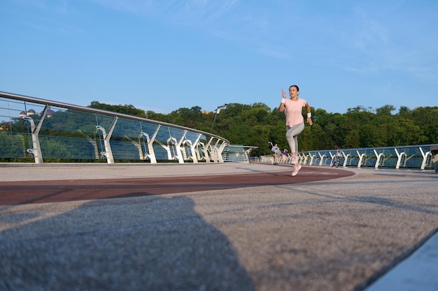 Portret Całego Ciała Sportsmenki, Lekkoatletki Biegacza Jogger Korzystających Z Porannego Joggingu Na Bieżni Mostu Miejskiego W Godzinach Porannych. Sport, Fitness, Trening Cardio I Koncepcja Aktywnego Zdrowego Stylu życia